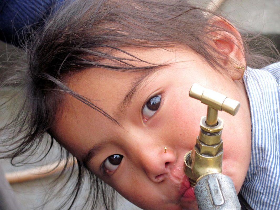 A girl drinks water from the tap at her school in the rural mountainous village of Barpar, Gorkha, Nepal. © 2010 Amrit Bhandary, Courtesy of Photoshare - 9672967_orig